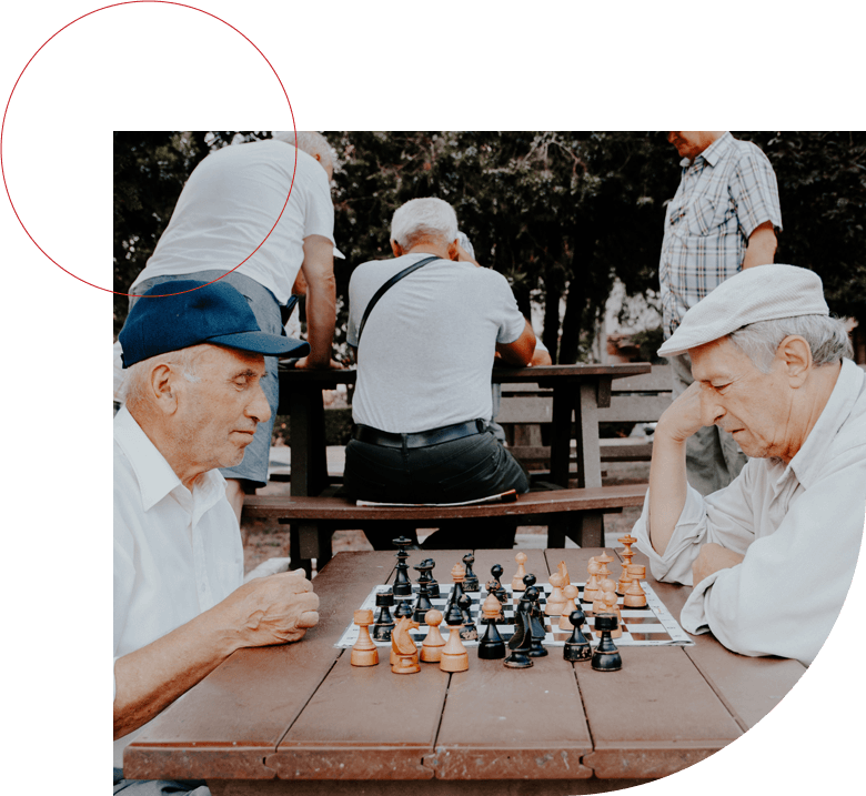 Portrait of two senior men playing chess in the park on a daytime in fall.